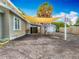 Exterior showcasing a tan shade sail covering the driveway to the house and the garage at 70 N Oak Ave, Umatilla, FL 32784