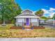 Charming home featuring a landscaped front yard, with a colorful purple door, and a fountain at 70 N Oak Ave, Umatilla, FL 32784