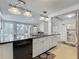 Kitchen island with stainless steel sink, black countertops, and views to the backyard and bathroom at 70 N Oak Ave, Umatilla, FL 32784