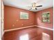 Cozy bedroom features wood floors, ceiling fan and two windows at 994 Country Lake Cir, Lake Wales, FL 33898