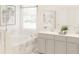 Bright bathroom featuring a soaking tub, double vanity, and modern fixtures at 4759 Waltham Forest Dr, Davenport, FL 33837