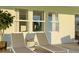 Relaxing outdoor patio features two lounge chairs, a small table, and bright sunlight streaming through the windows at 4759 Waltham Forest Dr, Davenport, FL 33837