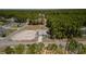 Aerial view of a home with a big yard, surrounded by a vibrant forest and other houses in the distance at 8007 Sw 135Th Loop, Ocala, FL 34473