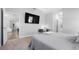Tranquil main bedroom with a large-screen TV, neutral tones, and a glimpse of the en-suite bathroom at 8007 Sw 135Th Loop, Ocala, FL 34473