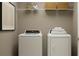 Efficient laundry room with washer, dryer, and storage shelving at 970 Hour Glass Rd, Lakeland, FL 33801