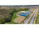 Aerial of the neighborhood sports complex, featuring tennis and basketball courts, with lush surroundings and new home construction at 2115 Forage Dr, Kissimmee, FL 34746