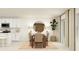 Dining area featuring a round mirror, stylish table with chairs, adjacent to an all-white kitchen at 2115 Forage Dr, Kissimmee, FL 34746