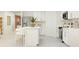 Open kitchen design with white cabinetry, stainless steel appliances, and an island with bar stools at 2115 Forage Dr, Kissimmee, FL 34746