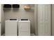 Well-lit laundry room featuring a white washer and dryer with storage shelves and a folding door at 2157 Albatross Nest Dr, Bartow, FL 33830
