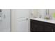 Bright bathroom with dark wood cabinets, double vanity, walk-in shower, and a clean, modern design at 2433 Spring Tune Aly, Kissimmee, FL 34744
