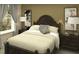 Cozy bedroom features a dark wood bed frame, natural light, and simple decor, creating a peaceful retreat at 2433 Spring Tune Aly, Kissimmee, FL 34744