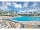 Beautiful community pool with lounge seating under palm trees with a community building at 2433 Spring Tune Aly, Kissimmee, FL 34744
