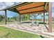 Open-air pavilion offering shaded seating with picnic tables, set on a brick patio and surrounded by greenery at 2433 Spring Tune Aly, Kissimmee, FL 34744