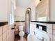 Retro bathroom with pink and black tile, vintage sink, and arched shower at 800 W Lake Elbert Ne Dr, Winter Haven, FL 33881