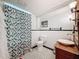 Quaint bathroom featuring a patterned shower curtain and classic tilework at 800 W Lake Elbert Ne Dr, Winter Haven, FL 33881