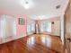 Bright bedroom featuring hardwood floors, pink walls, and ample natural light at 800 W Lake Elbert Ne Dr, Winter Haven, FL 33881