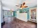 Spacious room with hardwood floors, large windows, ceiling fans, dresser and walk-in door to a side room at 800 W Lake Elbert Ne Dr, Winter Haven, FL 33881