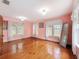 Large bedroom with hardwood floors, pink walls, and multiple windows at 800 W Lake Elbert Ne Dr, Winter Haven, FL 33881