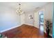 Bright dining room featuring hardwood floors, a chandelier, and an open doorway leading to the Primary bathroom at 800 W Lake Elbert Ne Dr, Winter Haven, FL 33881