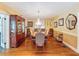 Elegant dining room with hardwood floors, a crystal chandelier, and ample space for entertaining guests at 800 W Lake Elbert Ne Dr, Winter Haven, FL 33881