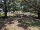 Charming yellow home with a large front porch and mature trees offering ample shade on a spacious lawn at 800 W Lake Elbert Ne Dr, Winter Haven, FL 33881