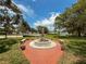 A scenic water fountain with seating, set amidst beautiful mature trees and a waterway beyond at 800 W Lake Elbert Ne Dr, Winter Haven, FL 33881