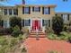 Close-up of the front entrance with a brick path and striking red double doors with sidelights at 800 W Lake Elbert Ne Dr, Winter Haven, FL 33881