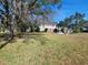 Charming two-story home featuring a lush green front yard with a decorative fountain and mature trees at 800 W Lake Elbert Ne Dr, Winter Haven, FL 33881