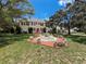 A two-story home featuring a striking red front door, complemented by a water fountain and mature trees at 800 W Lake Elbert Ne Dr, Winter Haven, FL 33881