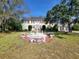Traditional-style two-story home with a circular driveway and white water fountain at 800 W Lake Elbert Ne Dr, Winter Haven, FL 33881
