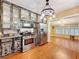 Eat-in kitchen with custom cabinets with glass doors, stainless appliances, and hardwood floors at 800 W Lake Elbert Ne Dr, Winter Haven, FL 33881