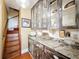 Butler's pantry features custom cabinetry with glass doors, granite counters, and easy access to the stairs at 800 W Lake Elbert Ne Dr, Winter Haven, FL 33881