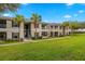 Exterior of a two-story condo complex with well-kept green lawn and mature palm trees at 4014 Hemingway Cir # 4014, Haines City, FL 33844