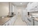 Bright kitchen featuring white appliances and cabinets, plus a stainless steel sink and faucet at 4014 Hemingway Cir # 4014, Haines City, FL 33844