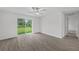 Bedroom with hardwood floors, ceiling fan, and sliding glass door to backyard at 1 Zinnia E Ln, Poinciana, FL 34759