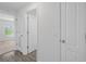 Hallway with wood-look floors and a view into a bedroom and bathroom at 1 Zinnia E Ln, Poinciana, FL 34759