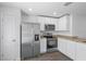 Modern kitchen with stainless steel appliances, white cabinets, and granite countertops at 1 Zinnia E Ln, Poinciana, FL 34759