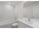 Clean bathroom featuring modern fixtures, white tile, and a large mirror at 414 Caribbean Ct, Poinciana, FL 34759