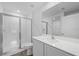 Bright bathroom with a glass enclosed shower, white cabinets, and a large mirror at 414 Caribbean Ct, Poinciana, FL 34759