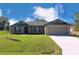 Charming single-story home featuring a manicured lawn, two-car garage and neutral-colored exterior at 414 Caribbean Ct, Poinciana, FL 34759