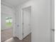 Hallway with wood-look flooring, neutral walls, and an open bedroom view at 414 Caribbean Ct, Poinciana, FL 34759