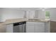 Kitchen island with granite countertop, stainless steel dishwasher, and white cabinetry at 414 Caribbean Ct, Poinciana, FL 34759