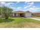 Well-maintained brick home with an attached garage and green lawn under a sunny sky at 492 Caribbean Dr, Lakeland, FL 33803