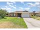 Charming brick home featuring a well-manicured lawn and attached two car garage at 492 Caribbean Dr, Lakeland, FL 33803