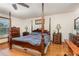 Spacious main bedroom featuring a four-poster bed, hardwood floors, and ample natural light at 492 Caribbean Dr, Lakeland, FL 33803