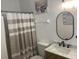 Updated bathroom featuring a neutral shower curtain, single sink vanity and framed mirror at 2057 Swift Rd, Oviedo, FL 32766
