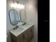Elegant bathroom with double sinks, black faucets, wood cabinets, and framed oval mirrors at 2057 Swift Rd, Oviedo, FL 32766