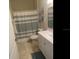 Bathroom features a vanity with storage, tiled floors, and a shower with a striped curtain at 2057 Swift Rd, Oviedo, FL 32766
