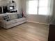 Bright living room featuring modern light gray sofa, adjacent to open kitchen, and light colored wood flooring at 2057 Swift Rd, Oviedo, FL 32766