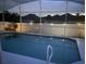 Screened pool area with landscape lighting provides a tranquil evening atmosphere at 2057 Swift Rd, Oviedo, FL 32766